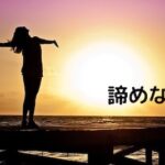 夕日を前に、何かを諦めない姿の女性