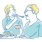 食事介助する介護職のイラスト