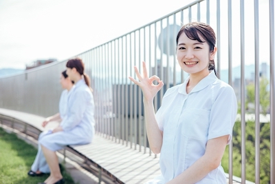 病院の屋上でほほえむ女性